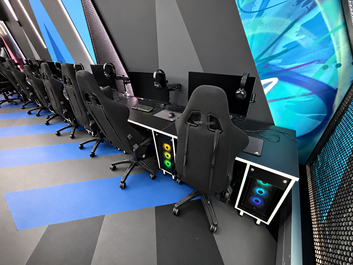 Black esports desks with white edging, under-desk PC holders and monitor arms at St Mary’s University